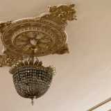 Qui spiccano i lampadari in ottone e cristallo che pendono da rosoni in stile liberty